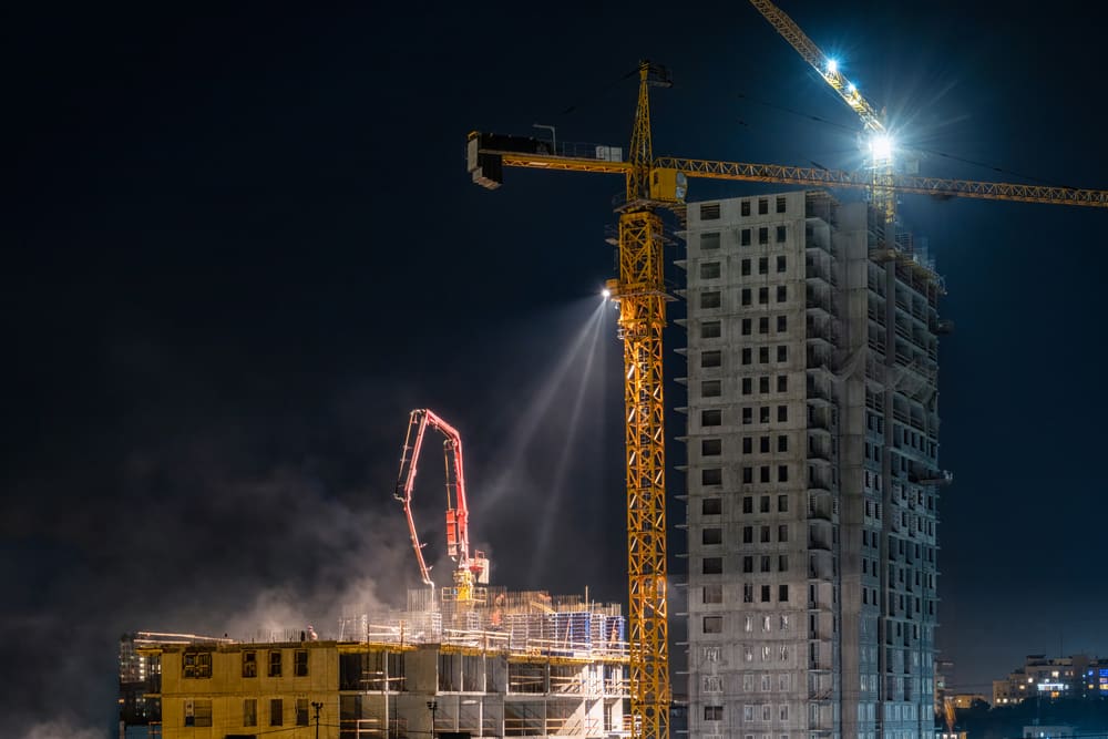 Tower cranes at a construction site at night