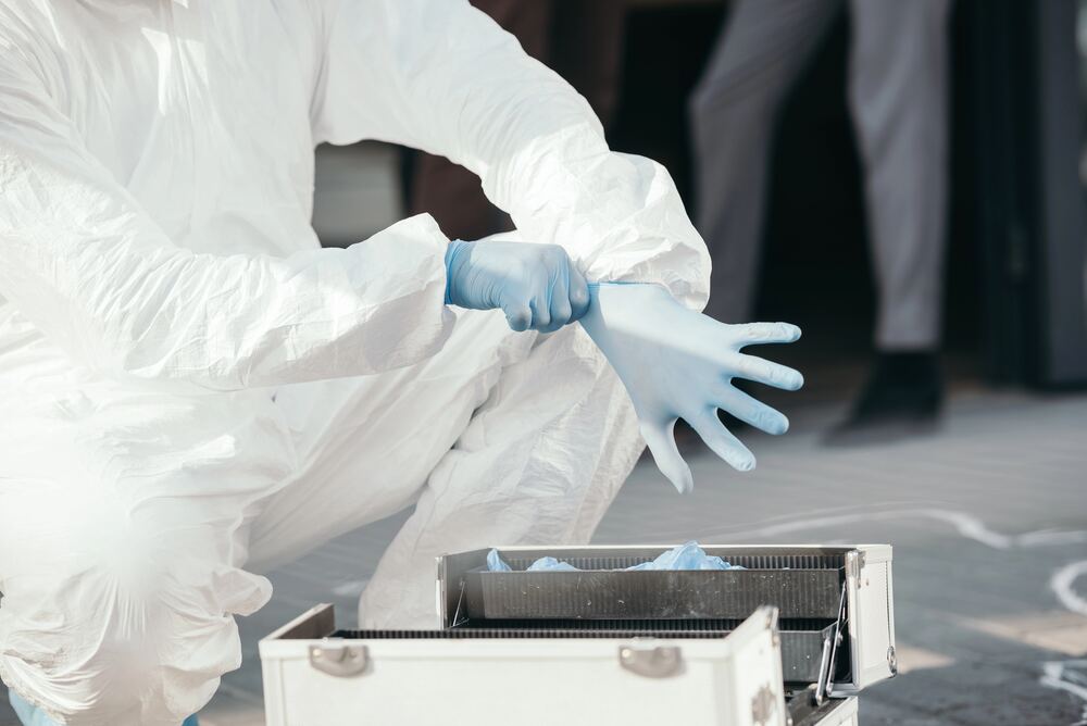 Technician in PPE preparing for hazardous residue sampling