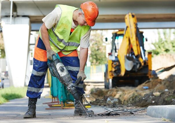 Construction worker operating a handheld breaker — hand-arm vibration source